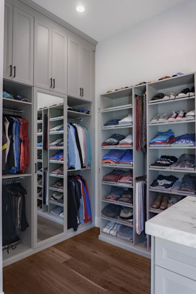 Photo of a Men's Master closet with this dress shirts nicely folded and hung with a mirrored door